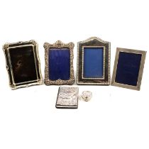 Two silver topped cologne bottles, pill box, two silver frames and address book.