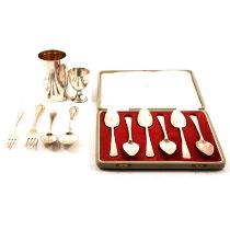 A cased set of silver grapefruit spoons, christening mug, egg cup and flatware.