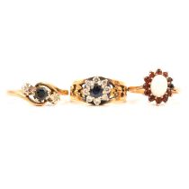 Three gemset rings, sapphire and diamond, opal and garnet.