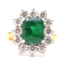 An emerald and diamond cluster ring.