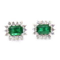 A pair of emerald and diamond cluster earrings.