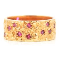 An 18 carat yellow gold band set with rubies.