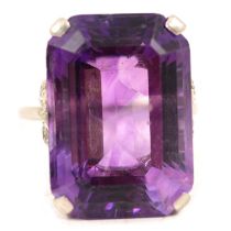 A large amethyst dress ring with diamond shoulders.