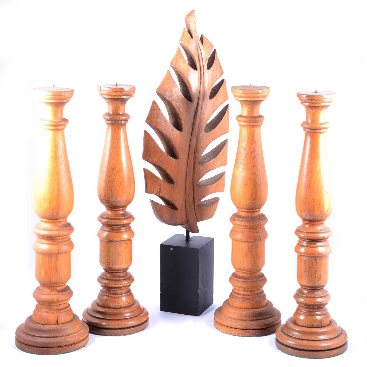 Set of four oak candlestands, and a leaf sculpture