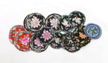 Four sets of eight circular Chinese silk embroidered mats and a set of three similar mats, all