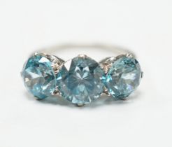 A white metal and three stone blue zircon set dress ring, size L, gross weight 4.1 grams.