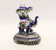 An Indian? white metal, polychrome enamel and gem set model of an elephant with Howdah, on octagonal