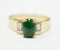 A 750 yellow metal, single stone cabochon jade and two stone baguette cut diamond set ring, size