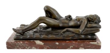 A late 19th/early 20th century bronze female nude reclining on a bed, on a red marble base, 32cm