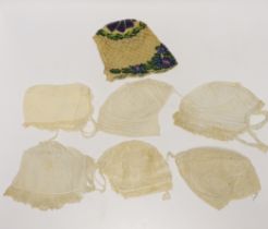 Seven baby bonnets, late 18th / 19th century, including a fine bobbin lace bonnet and unusual silk