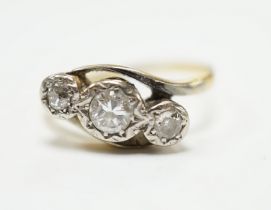 A yellow metal and illusion set three stone diamond set crossover ring, size O/P, gross weight 3.2