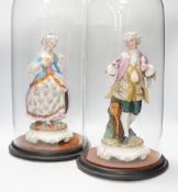 A pair of continental bisque porcelain figures, under glass domes, 48cm overall