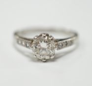 A platinum and single stone diamond set ring, with six stone diamond chip set shoulders, size P,
