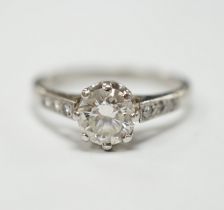 A platinum and single stone diamond set ring, with six stone diamond chip set shoulders, size P,