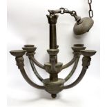 A bronze hanging ceiling light, with two tiers and eight face mask branches and large central