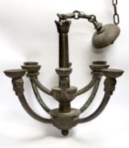 A bronze hanging ceiling light, with two tiers and eight face mask branches and large central