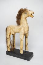 A painted, carved wood articulated model horse on stand, 42cm