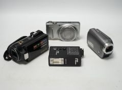 A collection of still and video cameras with accessories, including Samsung, Panasonic, Nikon,