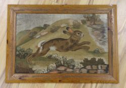 A late 19th century framed woolwork embroidered panel of a rabbit running through the countryside,