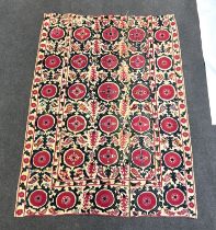 An 19th century Uzbek Suzani embroidered wall hanging, in two pieces, the main hanging sewn together