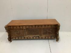 An Indian carved and panelled hardwood low chest, with figural motifs, width 148cm, depth 60cm,