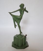 An Art Deco match striker in the form of a dancing woman, with patinated green finish, 25cm