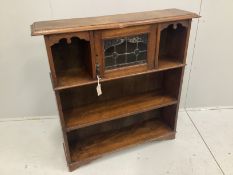 An Arts and Crafts oak open bookcase with leaded glazed door, width 102cm, depth 25cm, height 104cm