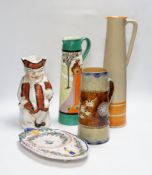A Bisto jug, two other jugs, a Toby jug and a Quimper saucer, tallest 39cm
