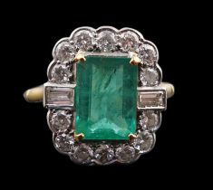 An Art Deco style gold, emerald and diamond set oval cluster ring, the central emerald measuring