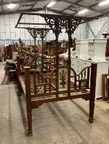 A 19th century Zanzibar hardwood bedframe inset reverse painted glass panels of peacocks and vases