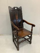 An 18th century oak elbow chair with twin panelled back, width 52cm, depth 50cm, height 110cm