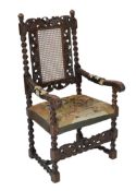 * * A Charles II carved walnut caned back elbow chair, with a contemporary needlework upholstered