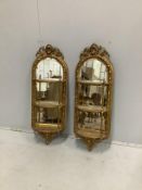 A pair of Victorian giltwood and composition mirrored three tier wall brackets, width 32cm, height