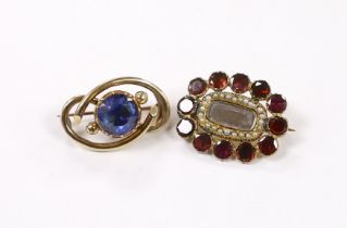 A Victorian yellow metal and single stone foil backed sapphire set scrolling mourning broch, verso