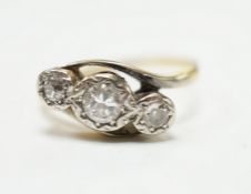 A yellow metal and illusion set three stone diamond set crossover ring, size O/P, gross weight 3.2