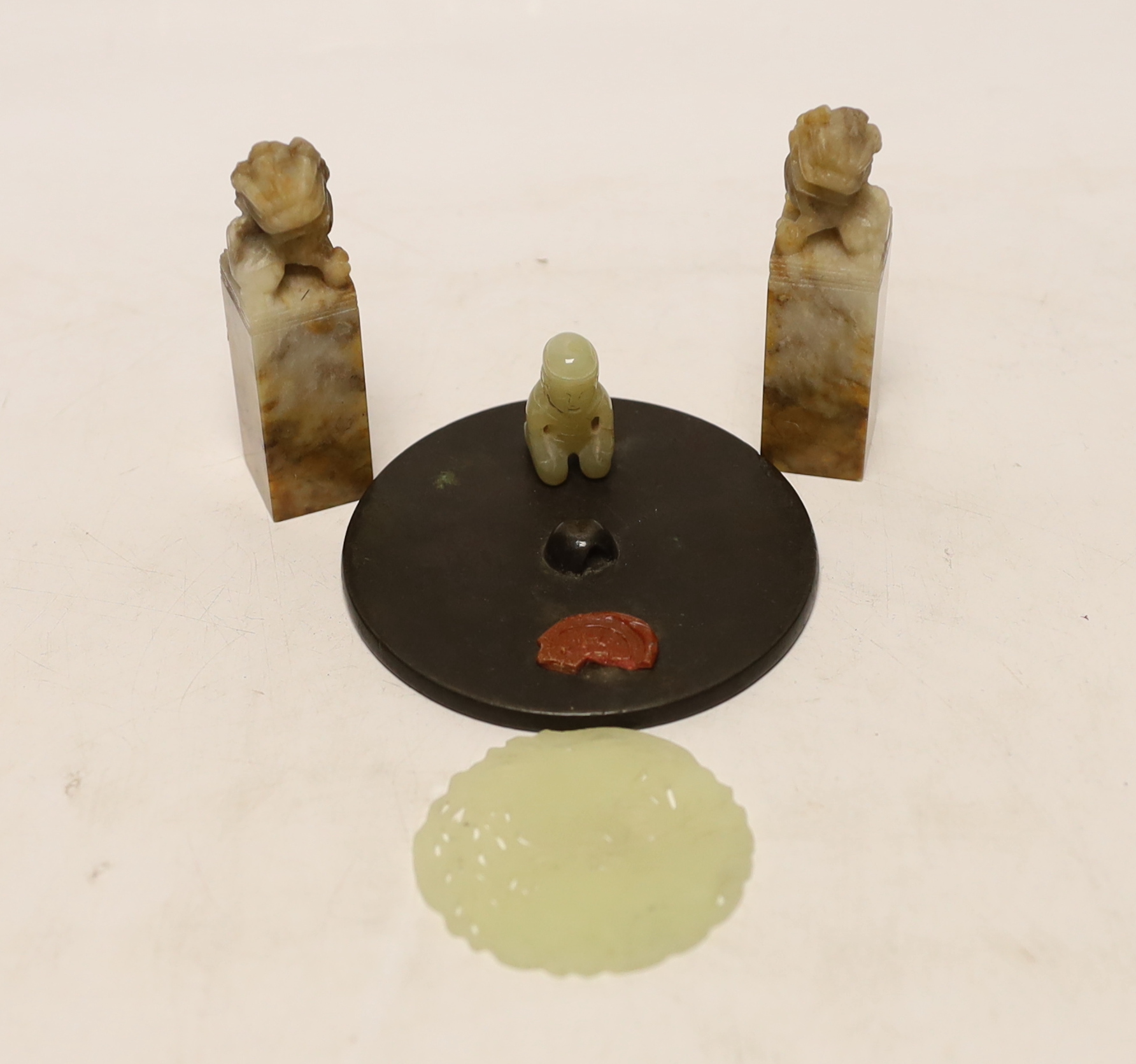 Two Chinese lion dog seals, a carved jade disc, a hard stone disc with partial wax seal and carved