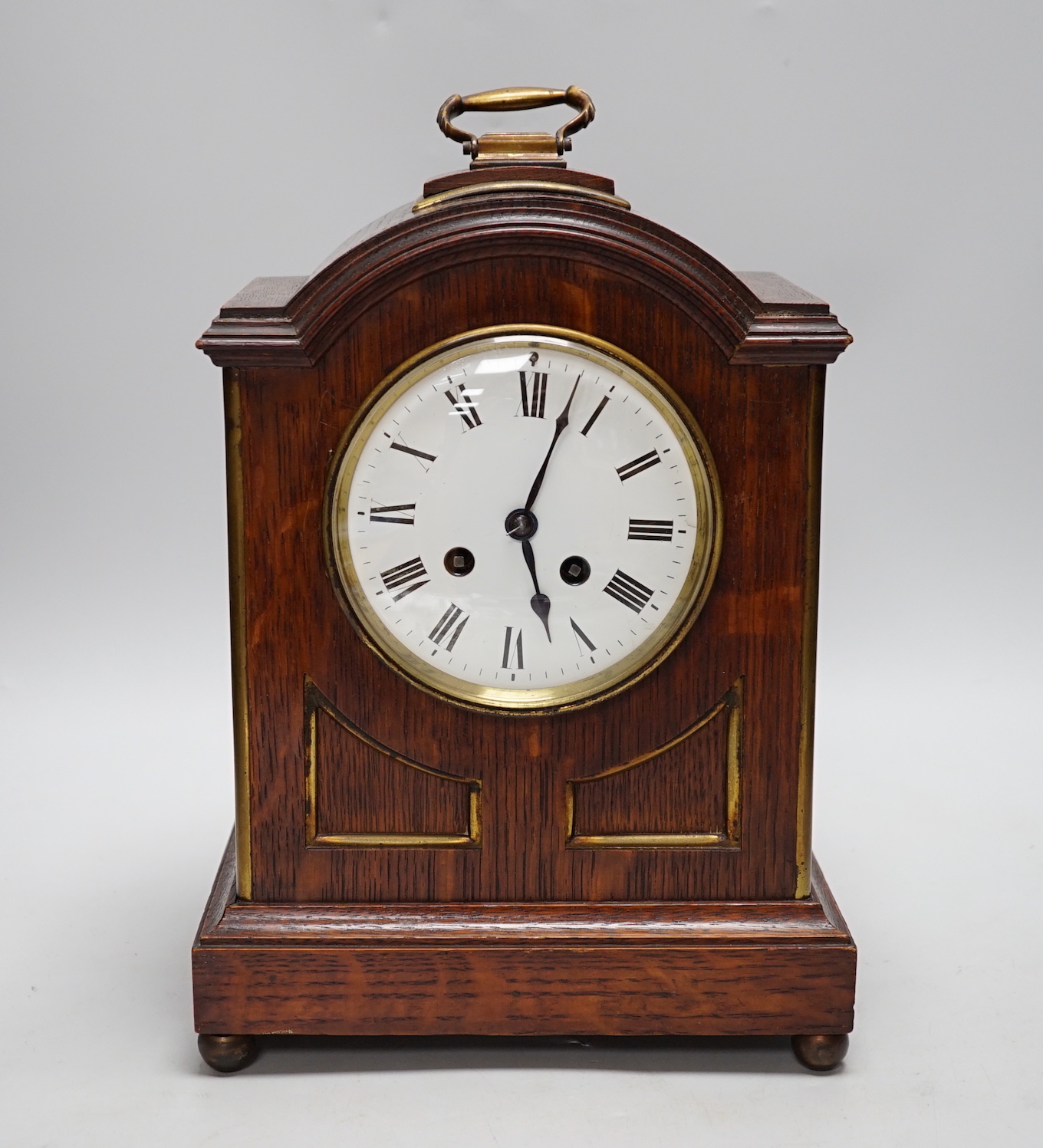 A oak mantel clock in a Regency style with pad top, striking on a coiled gong, 30cm high