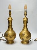 A pair of Sino-Tibetan gilt metal lamp bases set with cabochon stones