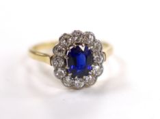 A 1940's/1950's 18ct, sapphire and millegrain set diamond oval cluster ring, size L/M, gross