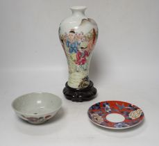 A Chinese famille rose vase, a rice dish, saucer and wooden stands