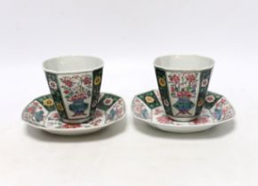 A pair of Chinese Qianlong famille rose octagonal cups and saucers, with panelled floral decoration,