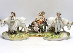 A pair of 19th century Staffordshire cow groups and an Italian donkey and cherub group, tallest 20.