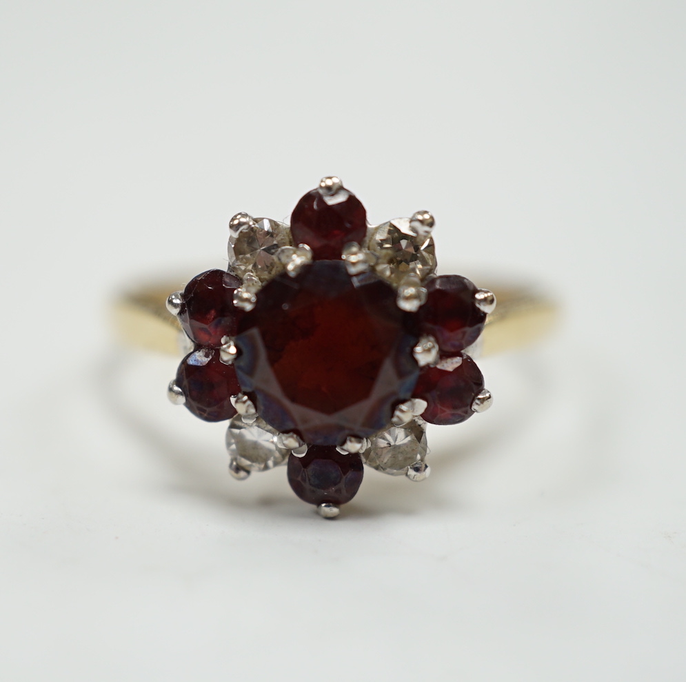 An 18ct red paste? and diamond cluster set flower head ring, size M, gross weight 3.2 grams.