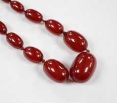 A single strand graduated simulated cherry amber necklace, 88cm, gross weight 74 grams.