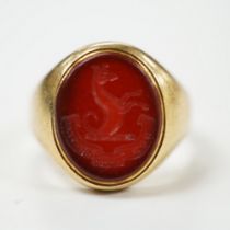 An 18ct and oval intaglio carnelian set signet ring, carved with family crest and motto, size K,