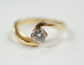 A modern 18ct gold and solitaire diamond set ring, with crossover shoulders, size K, gross weight