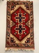 A Caucasian style red ground rug together with a North West Persian blue ground rug, larger 124 x