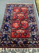 A Caucasian style red ground rug, 220cm x 140cm