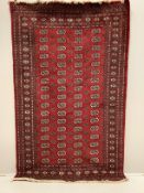 A Bokhara red ground rug, 250 x 155cm