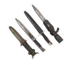 Four bayonets; two Mauser bayonets in scabbards, an American M8A1 carbine bayonet in a scabbard, and